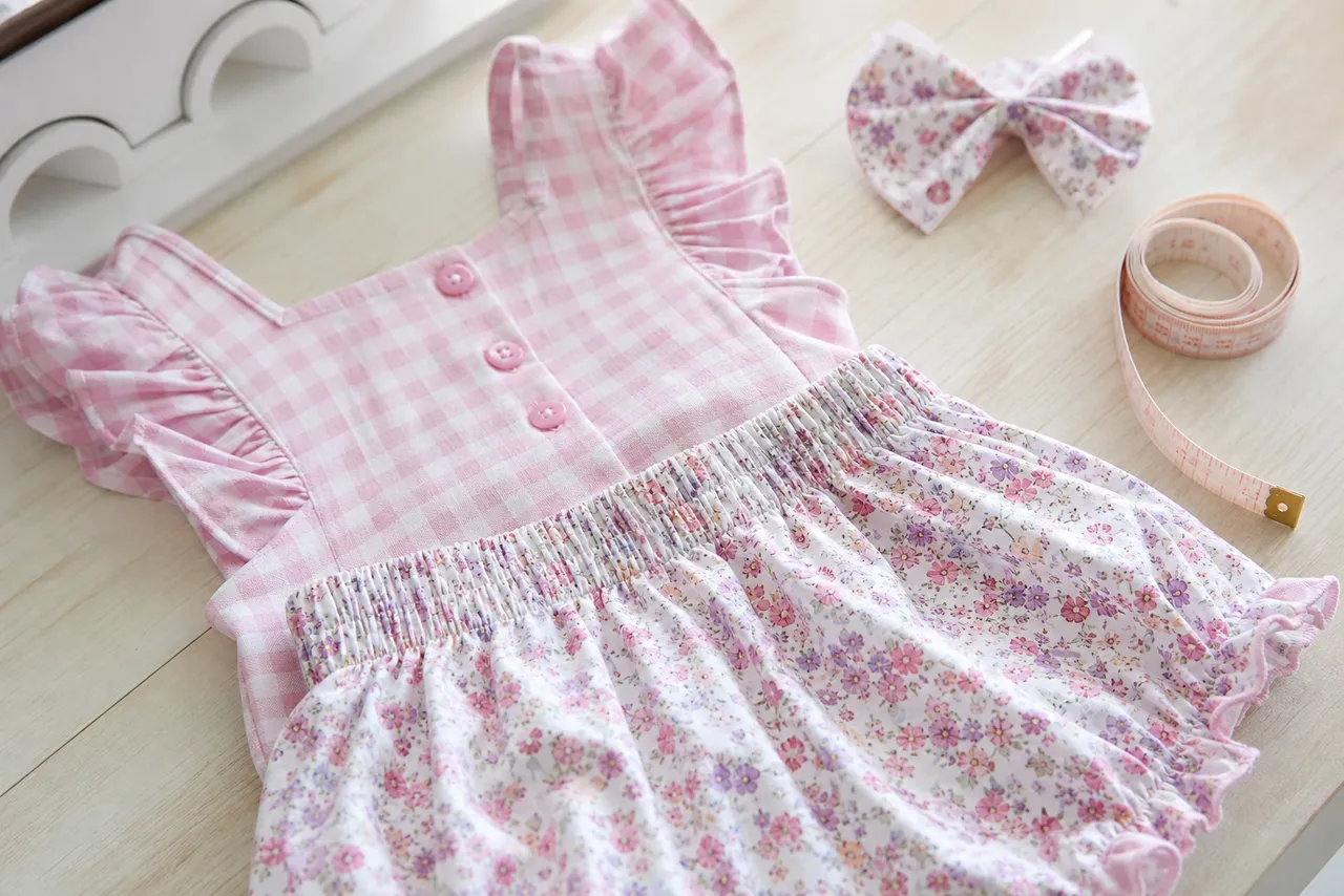 Detalhe de tecido, elástico, botões, laço e fita métrica de conjunto infantil feminino