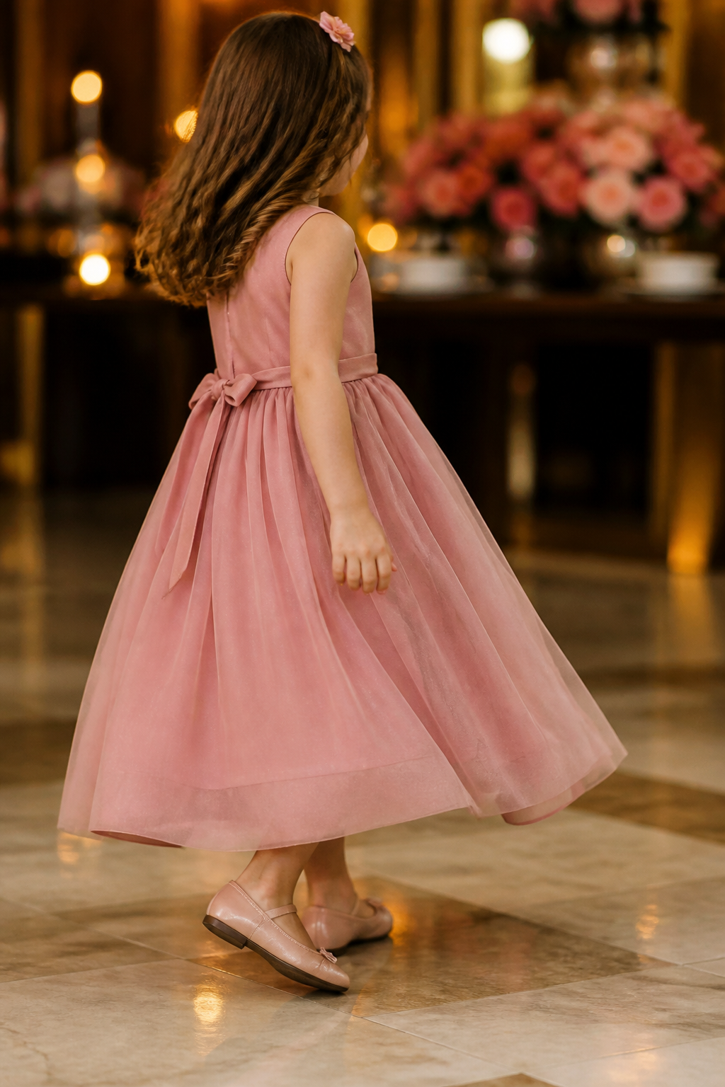 Menina com vestido infantil rosa caminhando com conforto em casamento