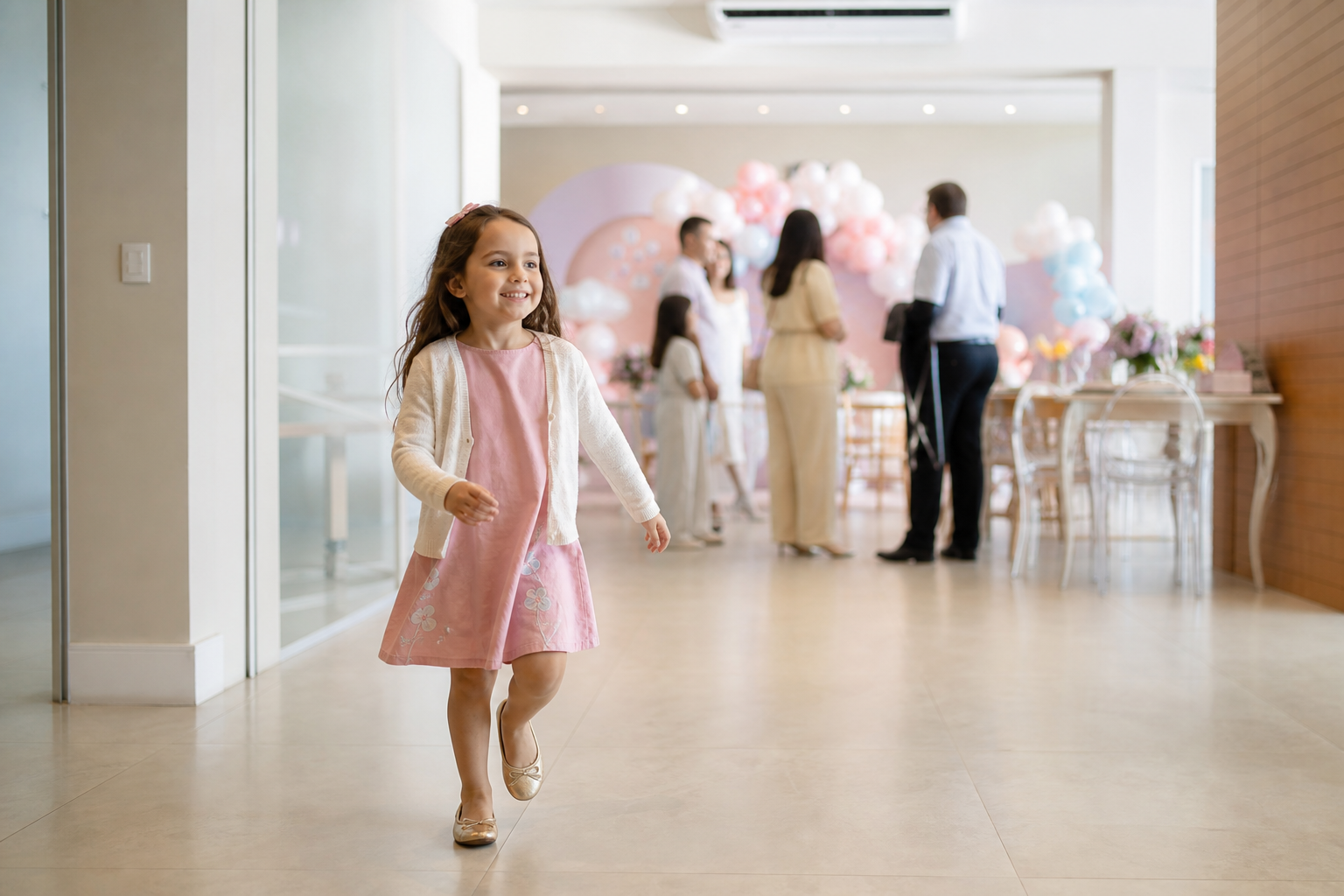 Menina com vestido e cardigan em festa infantil em salão climatizado