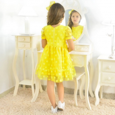 Mãe conferindo medidas e caimento de vestido infantil para aniversário